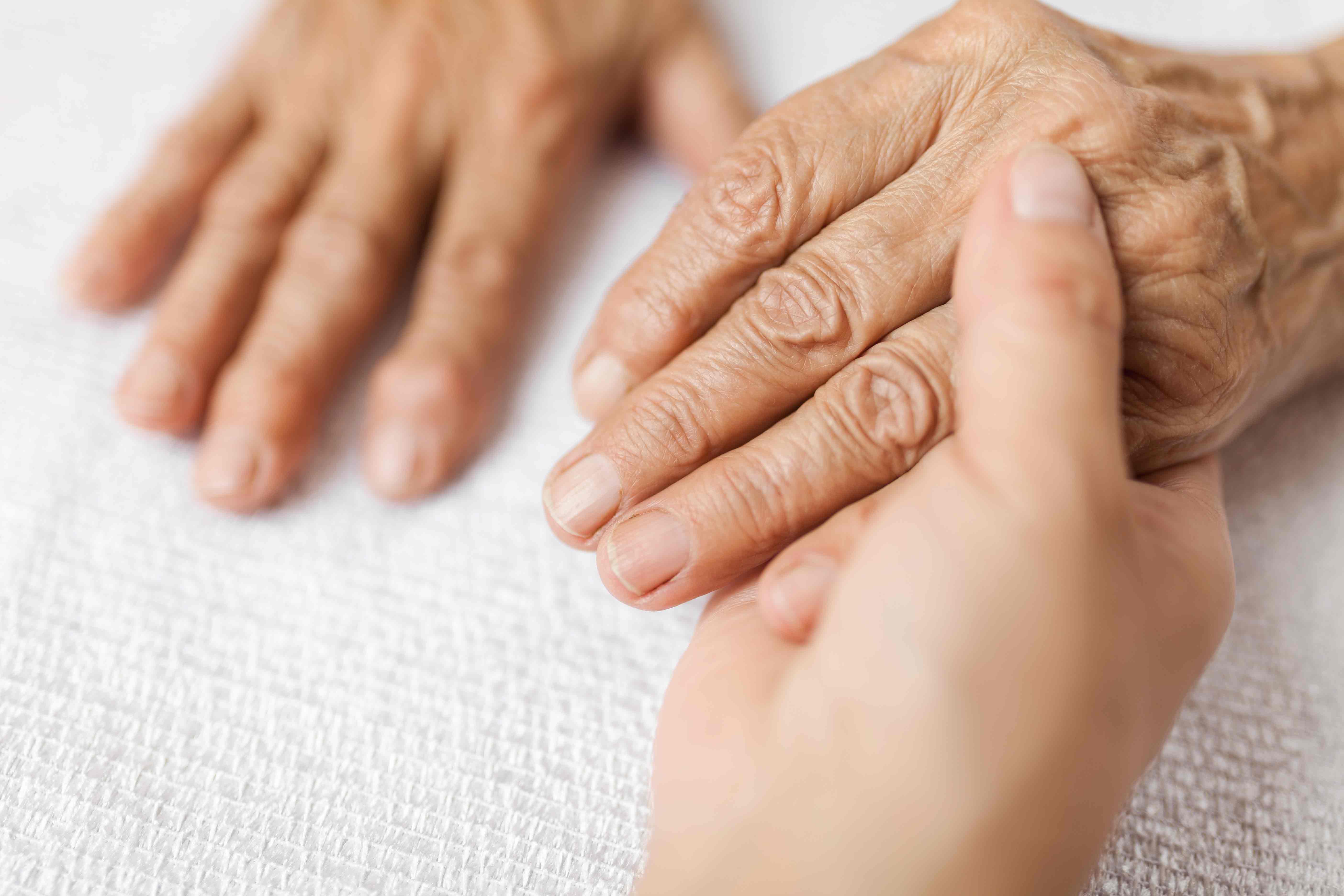 Caregiver Holding Elderly Woman's Hand - Memory Care Home Solutions - Family Caregiver Training